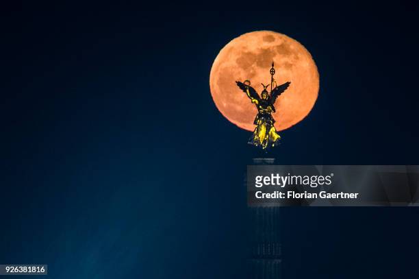 The full moon rises behind the so called 'Goldelse' on the top of the Berlin Victory Column on March 02, 2018 in Berlin, Germany.
