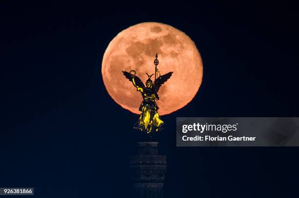 The full moon rises behind the so called 'Goldelse' on the top of the Berlin Victory Column on March 02, 2018 in Berlin, Germany.