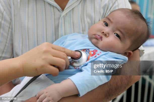 The Heart Institute offer high-quality care to Vietnamese patients suffering from heart diseases. Doctor listening to young baby's heart. Ho Chi Minh...