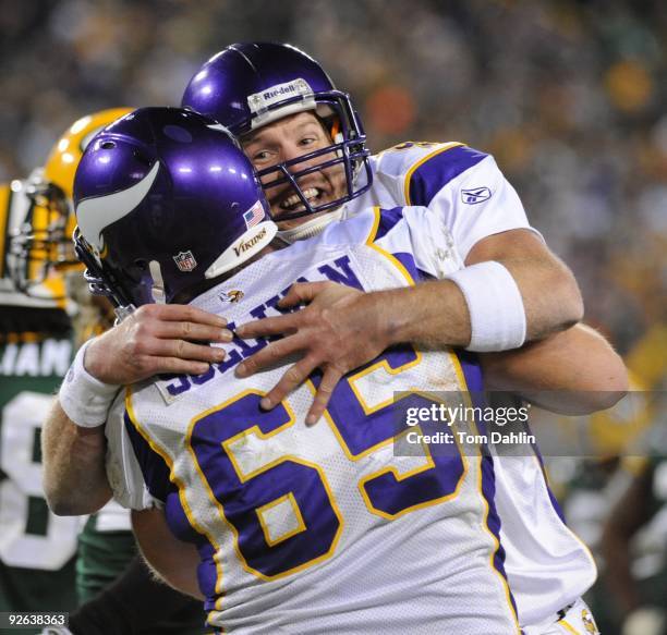 Brett Favre of the Minnesota Vikings celebrates with teammate John Sullivan during an NFL game against the Green Bay Packers at Lambeau Field on...