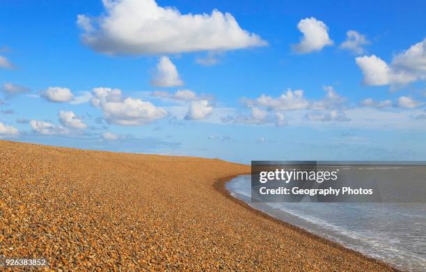 Steep beach profile sediment calm water blue sky white clouds landscape, Shingle Street, Suffolk, England, UK.