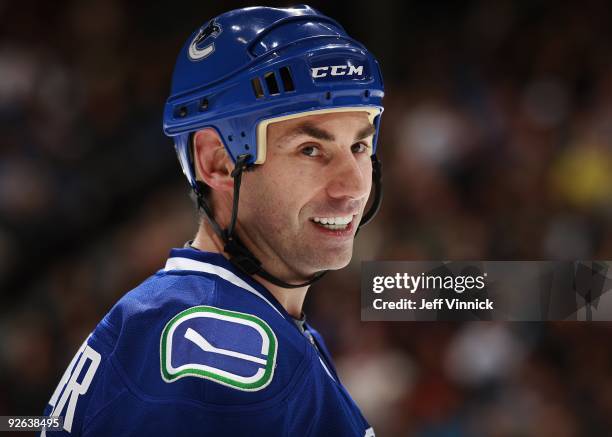 Mathieu Schneider of the Vancouver Canucks looks on from the bench during their game against the Edmonton Oilers at General Motors Place on October...