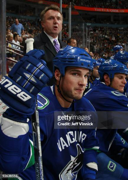 Associate coach Rick Bowness of the Vancouver Canucks and Shane O'Brien look on from the bench during their game against the Edmonton Oilers at...