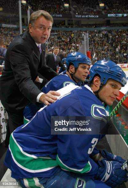 Associate coach Rick Bowness of the Vancouver Canucks and Kevin Bieksa look on from the bench during their game against the Edmonton Oilers at...