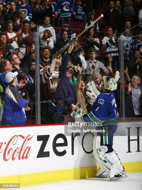 Roberto Luongo of the Vancouver Canucks gives his stick to a young fan during their game against the Edmonton Oilers at General Motors Place on...