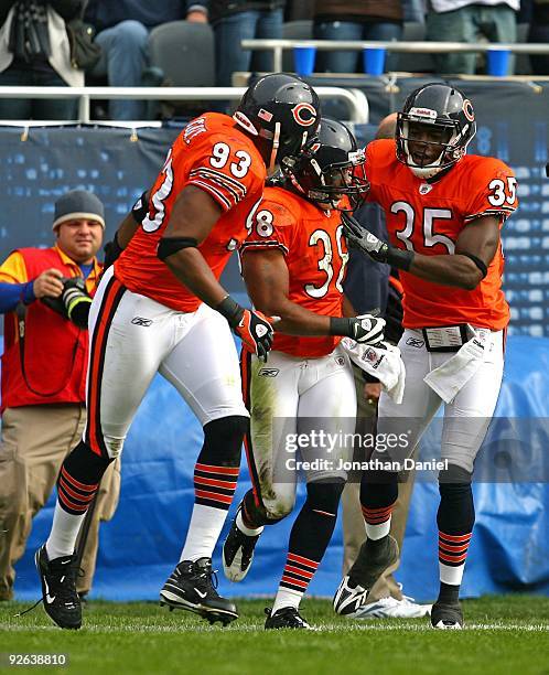 Danieal Manning of the Chicago Bears is congratulated by teammates Zackary Bowman and Adewale Ogunleye after returning an interception against the...