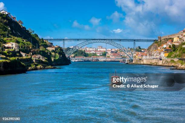 rabelo boat approaching the dom luis i bridge in porto portugal - rabelo boat stock pictures, royalty-free photos & images