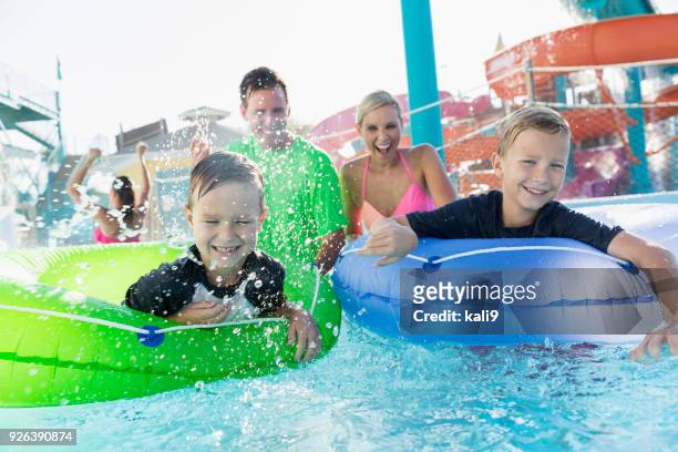 two boys and family having fun at water park - boy river looking at camera stock pictures, royalty-free photos & images