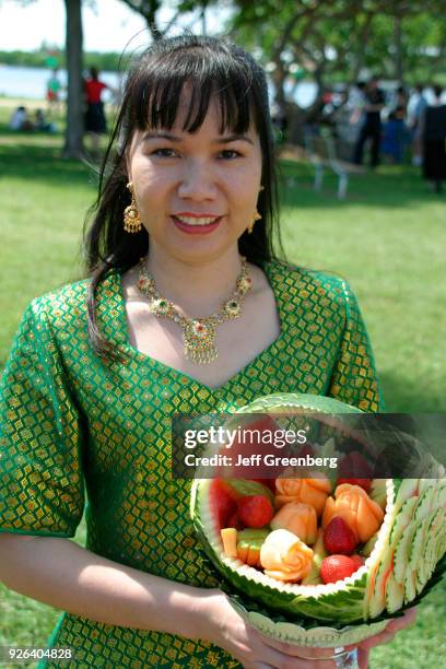 Woman from Thailand holding a carved watermelon at the Hong Kong Dragon Boat Festival.