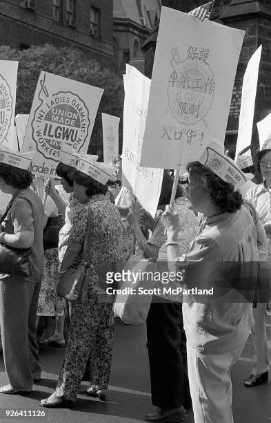 New York - Women garment workers with the ILGWU stand on the streets of Chinatown with protest signs in hand. They are protesting the increased...