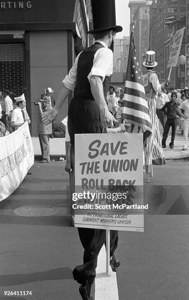 New York - Protesters on stilts stand on Broadway during an International Ladies Garment Workers Union rally. They are protesting the increased...