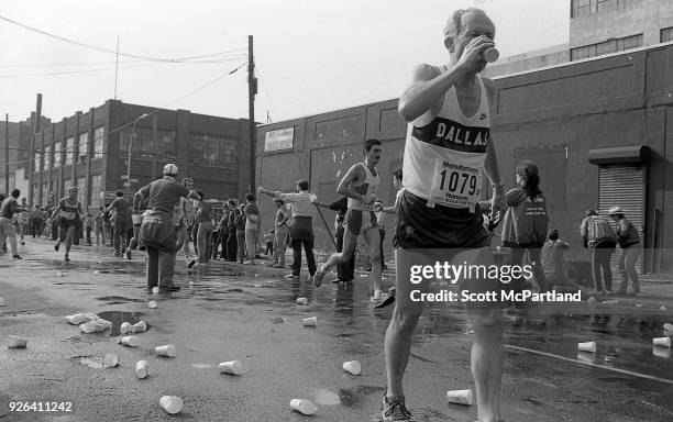 New York - An senior runner pauses for a drink of water at the 10 mile mark in Brooklyn during the NYC Marathon. Marathon volunteers hand out cups of...