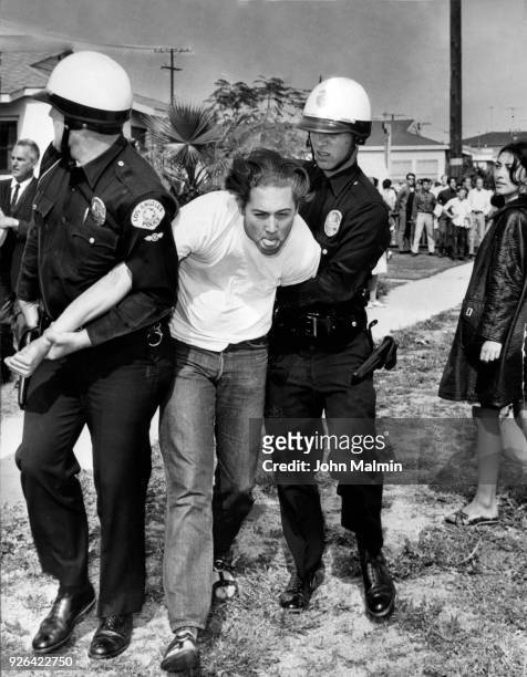 Image originally published on --A teenager identified as Wally Bauch a non-student, is arrested by policemen across the street from the Venice High...
