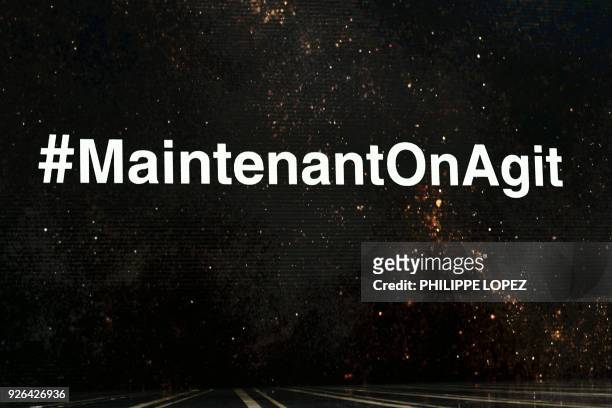 The hashtag MaintenantOnAgit in protest of violence against women is displayed on stage during the 43rd edition of the Cesar Awards ceremony at the...