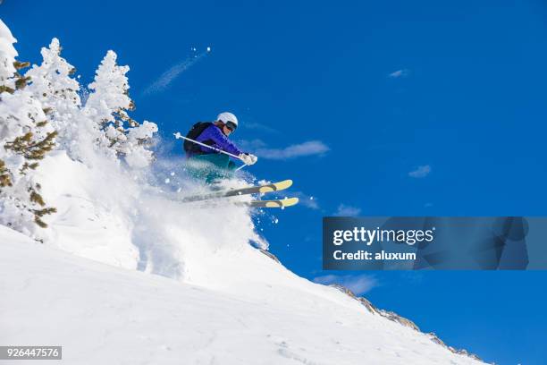 mujer saltando en nieve profunda durante el día de esquí en baqueira beret el pirineos cataluña españa - valle de arán fotografías e imágenes de stock