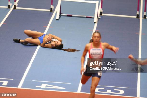 Elisavet Pesiridou lies on the track in pain after falling hard during the IAAF World Indoor Championships women's 60m hurdles.