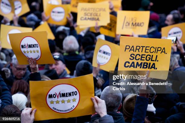 Supporters of the Five Stars Movement hold banners with the writing, government and Join, Choose and Change, during the closing rally of the italian...