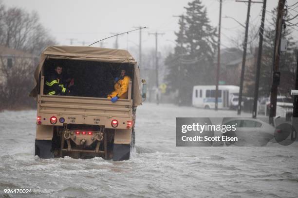 National Guard vehicle brings emergency workers to residents trapped by flood waters due to a strong coastal storm on March 2, 2018 in Quincy,...