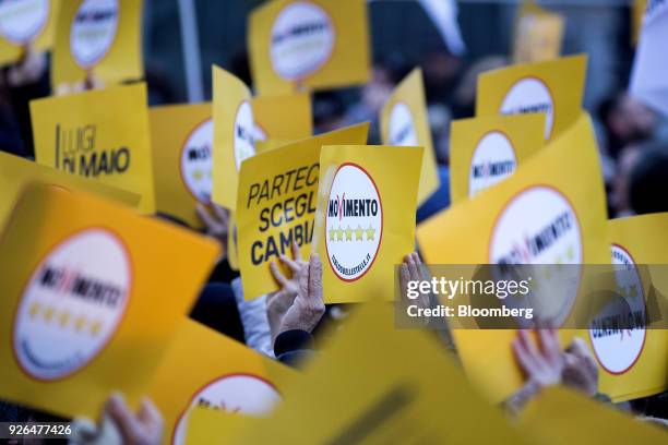 Attendees wave signs during a general election campaign rally for Luigi Di Maio, leader of Italy's anti-establishment Five Star Movement, not...