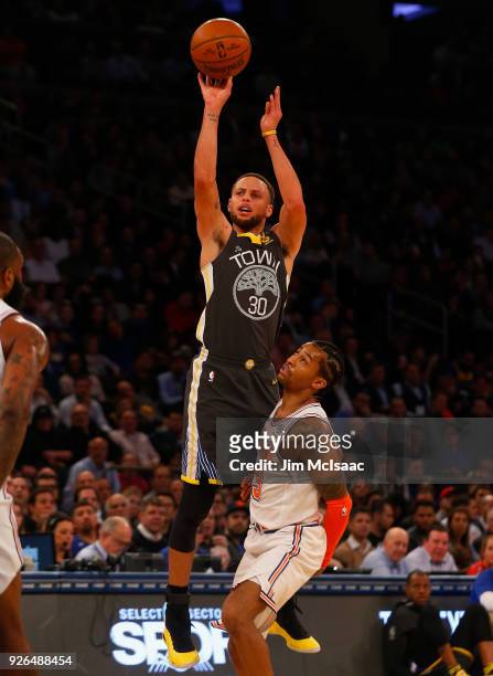 Stephen Curry of the Golden State Warriors in action against Trey Burke of the New York Knicks at Madison Square Garden on February 26, 2018 in New...