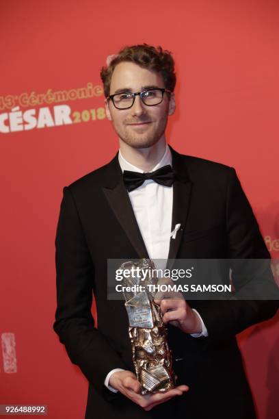 Film producer Remi Grellety poses with the trophy he accepted on behalf of Haitian filmmaker Raul Peck for the Best Documentary Feature award for the...