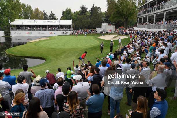 Fans cheer after Dustin Johnson makes a birdie on the seventeenth hole during round two of the World Golf Championships-Mexico Championship at Club...