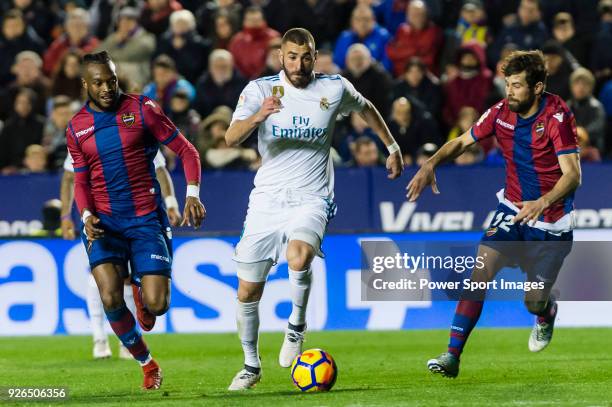 Karim Benzema of Real Madrid fights for the ball with Cheik Doukoure of Levante UD and Jorge Andujar Moreno, Coke, of Levante UD during the La Liga...