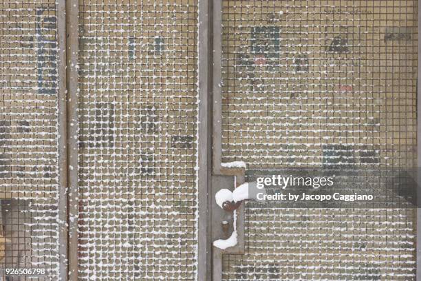 snow pattern on a metal grid - jacopo caggiano stock-fotos und bilder