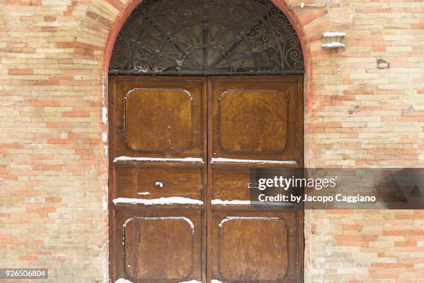 snow on a closed wooden door - jacopo caggiano stock pictures, royalty-free photos & images