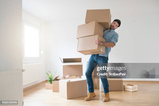 nothing's too tough for this guy - man boxes moving home stock pictures, royalty-free photos & images