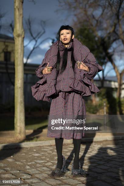 Guest is seen on the street attending Undercover during Paris Fashion Week Women's A/W 2018 Collection wearing an avant garde burgundy/navy plaid...
