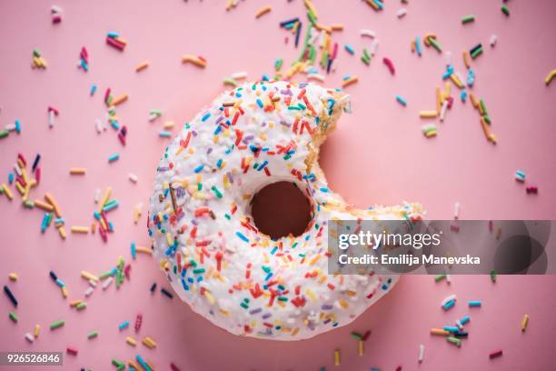 close-up of white donuts with multi colored sparks - buñuelo en forma de rosca fotografías e imágenes de stock