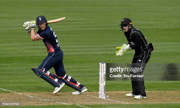 England batsman Ben Stokes hits out watched by Tom Latham during the 3rd ODI between New Zealand and England at Westpac stadium on March 3, 2018 in...