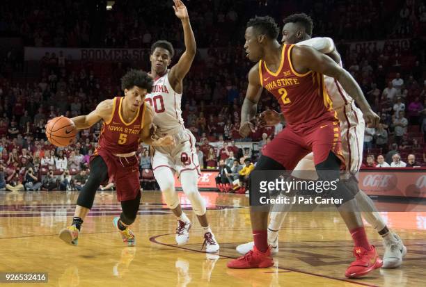 Tyler Cook of the Iowa Hawkeyes drives around Kameron McGusty of the Oklahoma Sooners during the first half of a NCAA college basketball game at the...