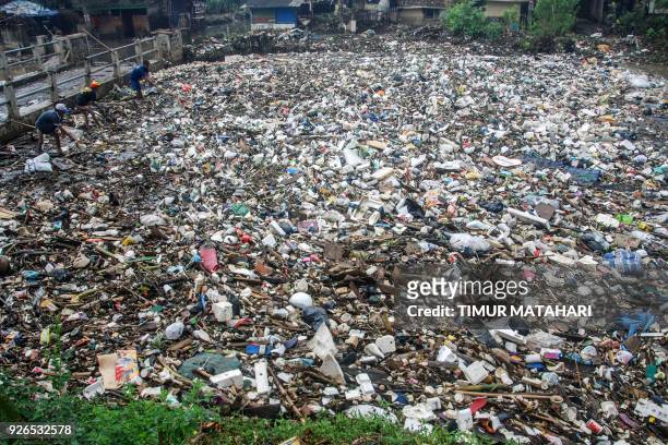Villagers search for recyclable waste as they stand on top of floating garbage covering the Citarum river in Bandung, West Java province on March 3,...
