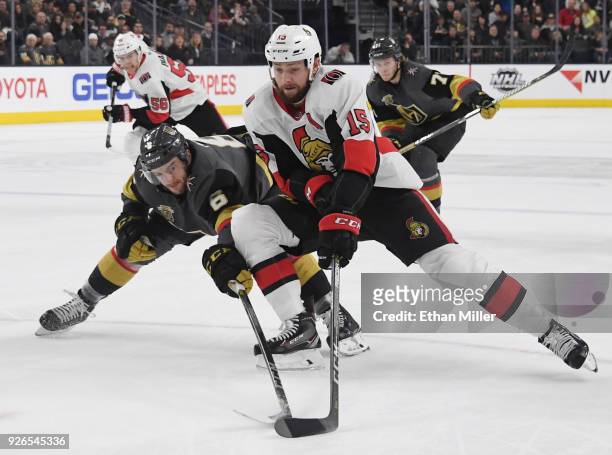 Zack Smith of the Ottawa Senators skates with the puck under pressure from Colin Miller of the Vegas Golden Knights in the first period of their game...