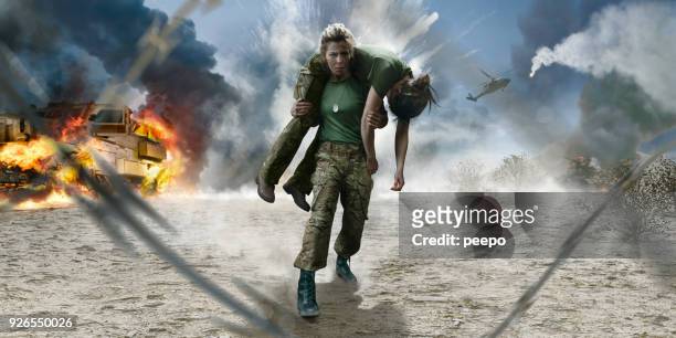 ejército femenino medic soldier lleva a soldado herido del campo de batalla desierto - víctima de accidente fotografías e imágenes de stock