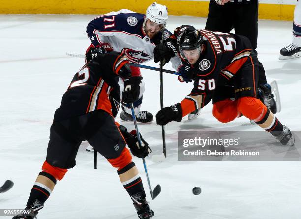 Nick Foligno of the Columbus Blue Jackets battles in a face-off against Antoine Vermette and Chris Kelly of the Anaheim Ducks during the game on...