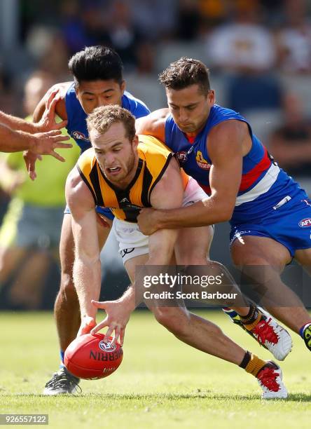 Tom Mitchell of the Hawks competes for the ball with Lin Jong of the Bulldogs and Luke Dahlhaus of the Bulldogs during the AFL JLT Community Series...