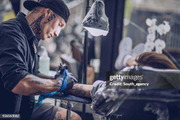girl getting arm tattoo - tattoo spectacular stock pictures, royalty-free photos & images