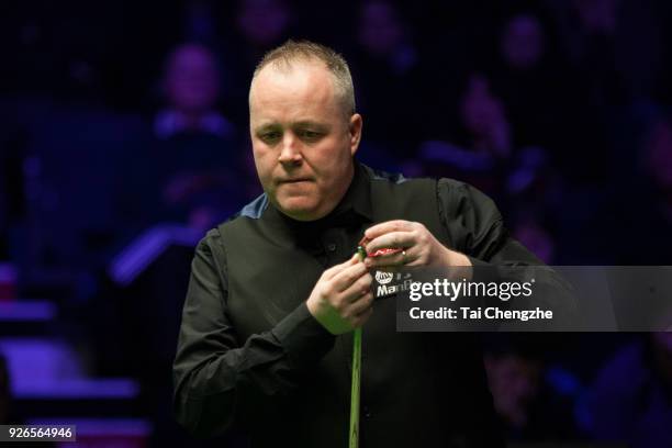 John Higgins of Scotland chalks the cue during his quarter-final match against Ronnie O'Sullivan of England on day five of 2018 ManBetX Welsh Open at...