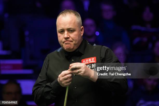 John Higgins of Scotland chalks the cue during his quarter-final match against Ronnie O'Sullivan of England on day five of 2018 ManBetX Welsh Open at...