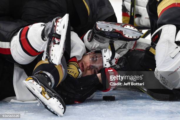 Mark Borowiecki of the Ottawa Senators looks out from under a pile of players against the Vegas Golden Knights during the game at T-Mobile Arena on...