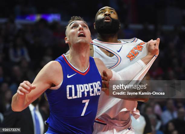 Sam Dekker of the Los Angeles Clippers and Kyle O'Quinn of the New York Knicks go for a rebound under the basket in the second half of the game at...