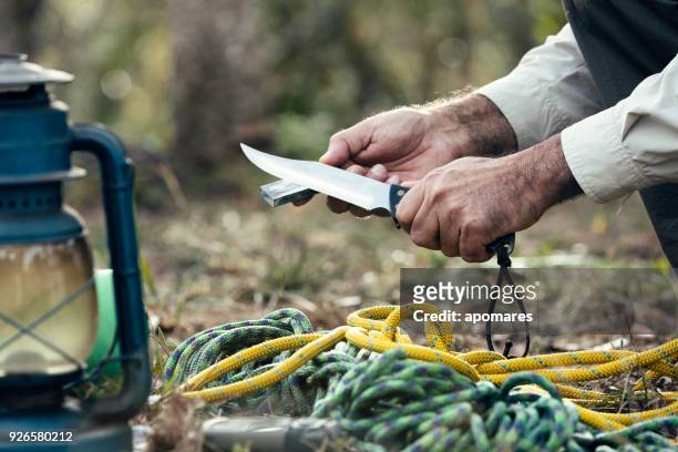 homem mãos afiar faca ao ar livre no deserto - utility knife - fotografias e filmes do acervo
