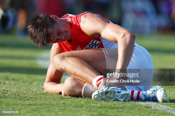 Callum Sinclair of th Swans grimaces after an injury during the AFL JLT Community Series match between the Brisbane Lions and the Sydney Swans at...