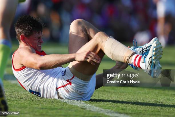 Callum Sinclair of th Swans grimaces after an injury during the AFL JLT Community Series match between the Brisbane Lions and the Sydney Swans at...