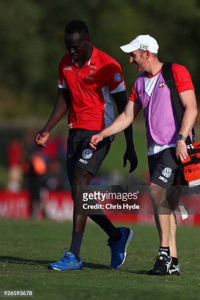 Aliir Aliir of the Swans walks with a physio during the AFL JLT Community Series match between the Brisbane Lions and the Sydney Swans at Moreton Bay...