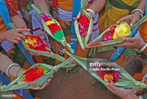 Students of Visva-Bharati University carry colour powder in palm leave canoe to start the dance in a procession to celebrate Basanta Utsav to mark...