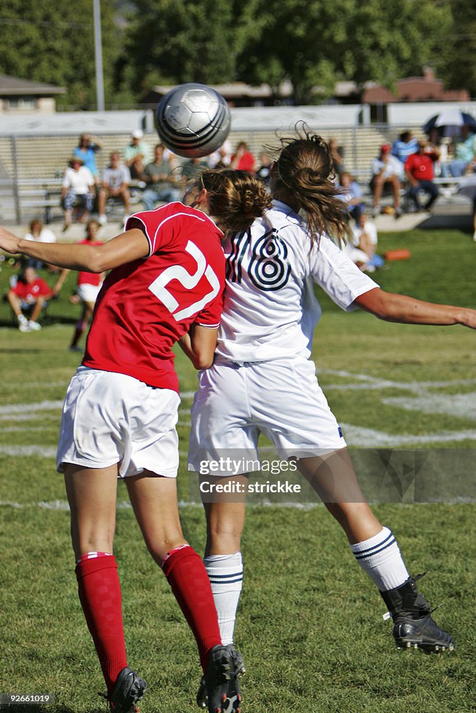 Two Female Soccer Players Put Double Header on Ball